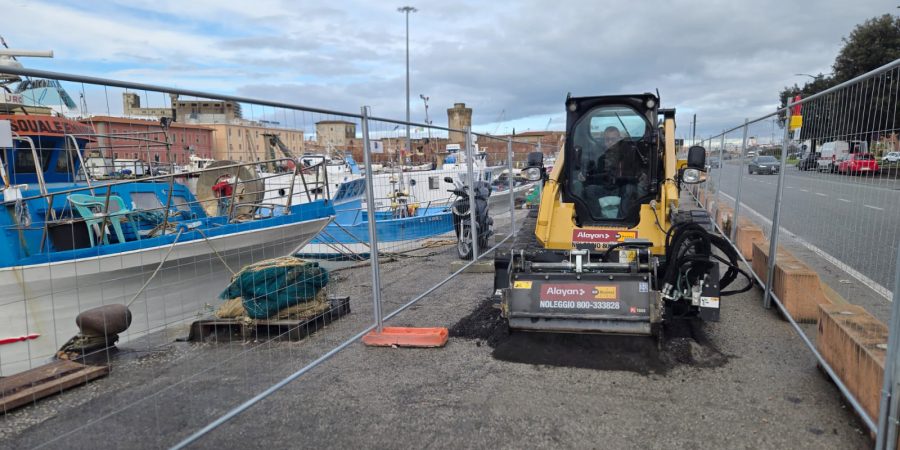 Rental compact track loader by Alayan Rentals equipped with an asphalt cold planer operating inside a port construction site.