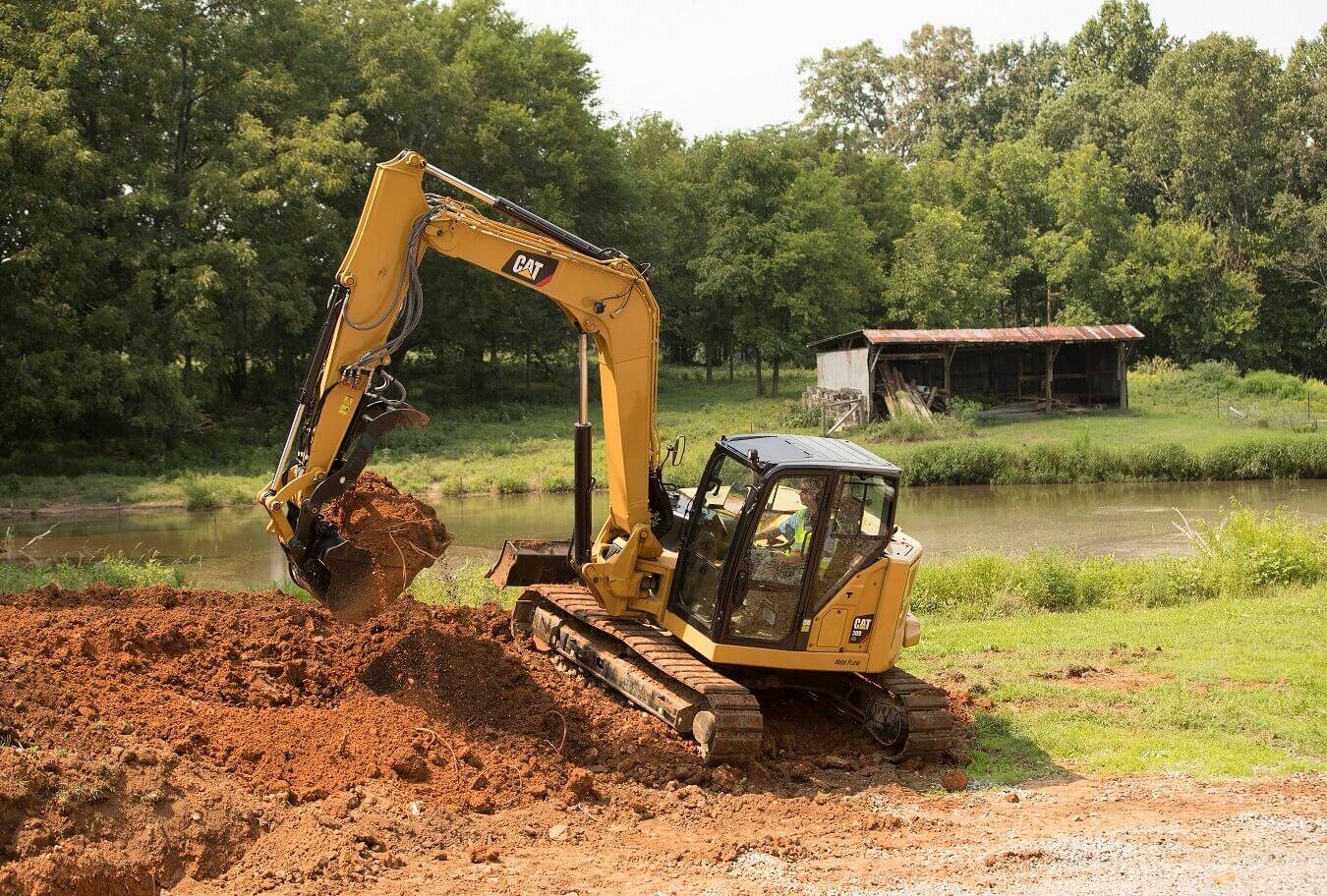 Escavatore Caterpillar a noleggio CGTE durante lavoro di scavo per opere di cura del verde Alayan (CGTE) Vermietung: