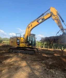 Escavatore cingolato Caterpillar CAT 309 giallo con cabina in cantiere stradale urbano a noleggio Alayan Rentals