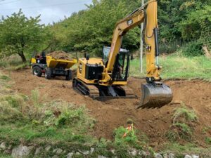 Minidumper gommato al lavoro con escavatore cingolato