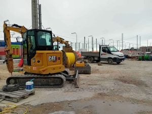 Yellow Caterpillar CAT 305 tracked mini excavator equipped with hydraulic breaker on jobsite for rent – Alayan Rentals