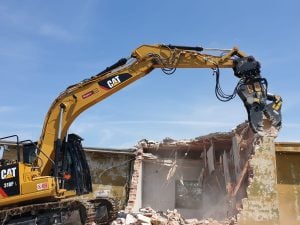 Hydraulische Abbruchzange montiert an einem Caterpillar CAT 318F L Raupenbagger beim Gebäuderückbau zur Miete – Alayan Rentals