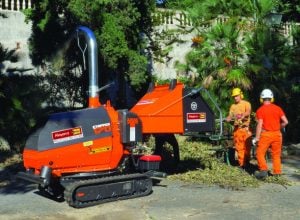 Operatori al lavoro con biocippatore cippatrice cingolata Chipper 130 a noleggio Alayan Rentals per la triturazione di rami e ramaglie da potatura