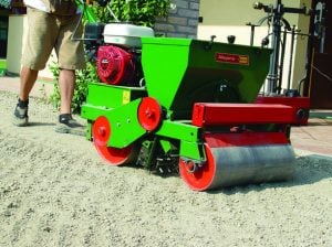 Operatore al lavoro con una seminatrice professionale per manti erbosi Sembdner con motore Honda a noleggio Alayan Rentals