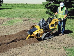Bediener bei der Arbeit mit einer Vermeer TRX 200 Grabenfräse zur Miete von Alayan Rentals beim Ausheben eines schmalen, präzisen Grabens im Boden