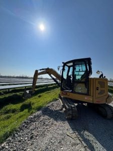 Gelber Caterpillar CAT 306 Raupenminibagger auf der Baustelle eines Solarparks zur Miete – Alayan Rentals