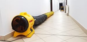 Gelber professioneller Master Luftentstauber-Ventilator mit flexiblem Luftsaug-Schlauch im Flur zur Miete – Alayan Rentals