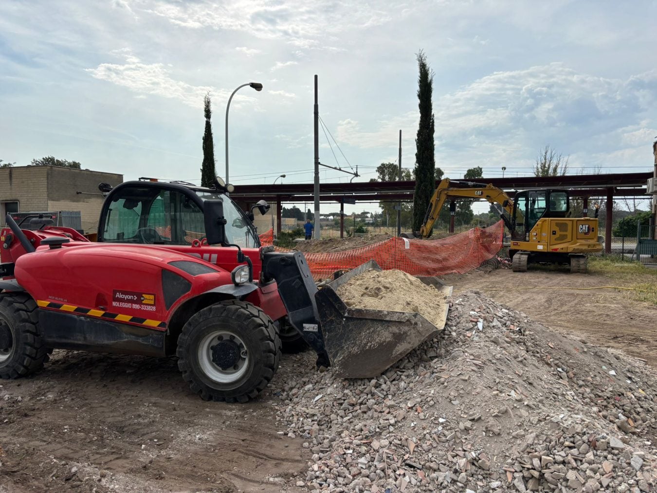 Alayan Rentals Manitou telehandler at a construction site near a railway station Alayan Rental