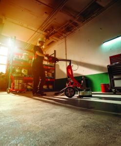 Operator working with CG 280 concrete grinder connected to an Alayan Rentals industrial dust extractor
