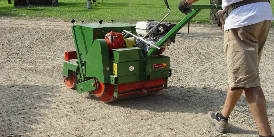 Rental Sembdner mechanical lawn seeder and roller by Alayan Rentals operating on leveled soil.