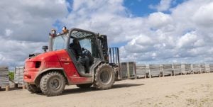 Carrello elevatore fuoristrada Manitou MH 25-4T Buggie rosso in funzione su terreno sterrato a noleggio Alayan Rentals