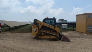 Seitenansicht des Caterpillar 265 Raupenladers von Alayan Rentals bei einer Photovoltaikanlage