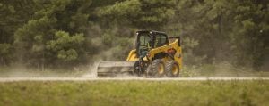 Caterpillar 289D3 tracked loader with pallet forks loaded with stone blocks at a job site for rent by Alayan Rentals