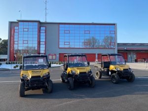 Flotta di tre veicoli utilitari UTV Polaris Ranger gialli a noleggio Alayan Rentals schierati nel piazzale esterno di una struttura direzionale